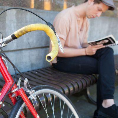 An SPU student reading a book near his bike in Martin Square